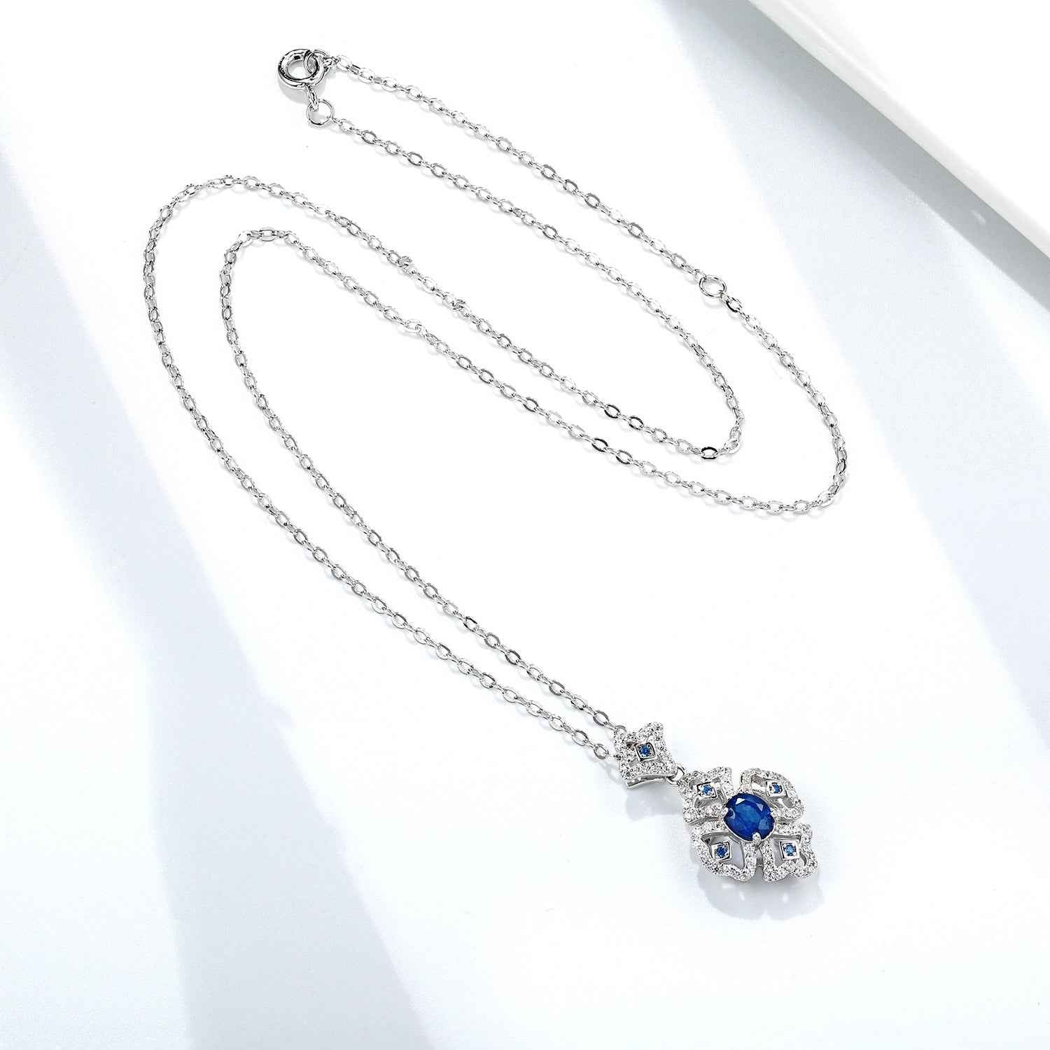 Silver chain necklace with oval blue sapphire floral pendant