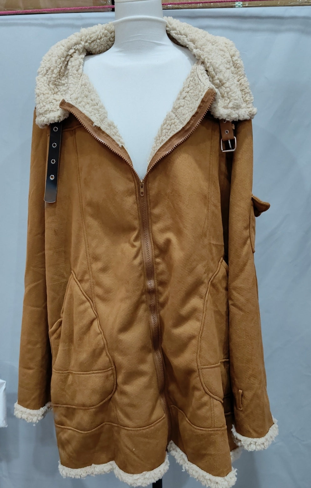 Men's winter jacket on mannequin, tan-brown coat with cream sherpa collar and zip-front