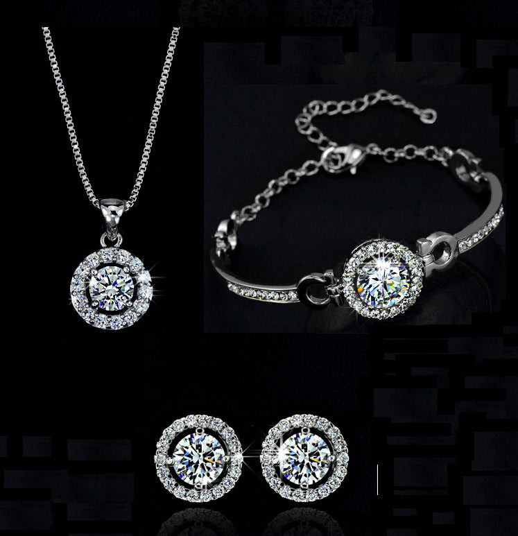 Silver jewelry set featuring round pendant necklace, bracelet with round centerpiece, and studs