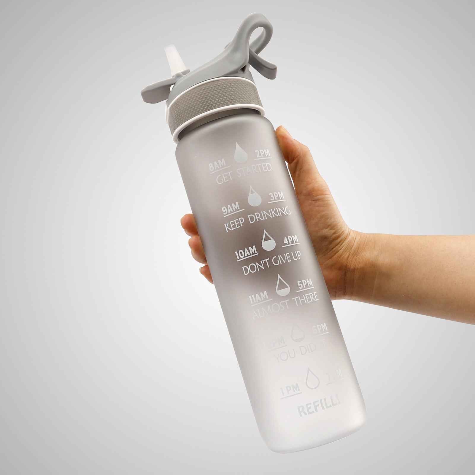 Water bottle with flip straw cover, gray gradient, printed hydration timing and refill label.