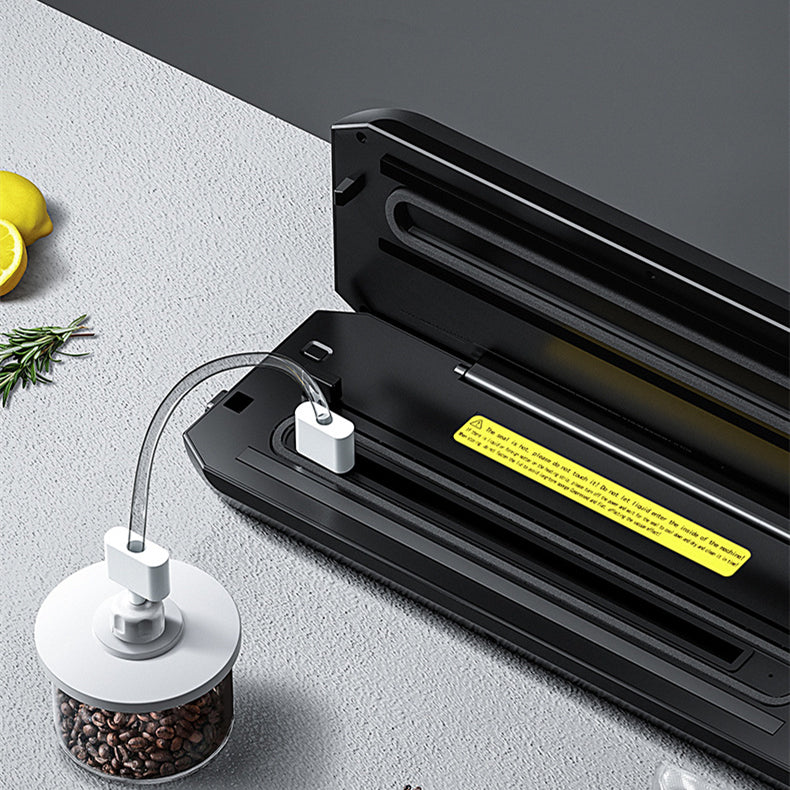 Black vacuum sealer base with sealing bar and power plug on counter