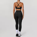 Women’s black sports bra and workout pants set with white dot print, crisscross back