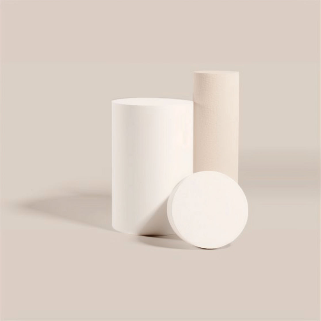 Set of white cylindrical rolls and a round disc on a flat surface